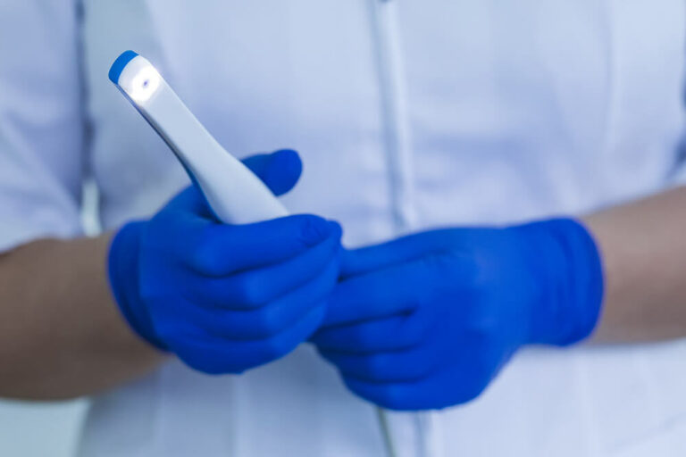 Doctor holding an intraoral camera used to take digital images of a patient's bite instead of using messy impression putty.