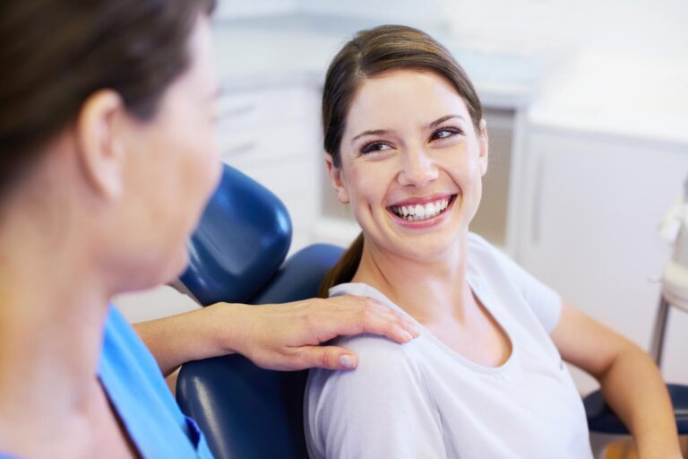 A pretty young woman having a conversation with her friendly dentist